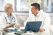 Female and male doctor e-learning on a laptop